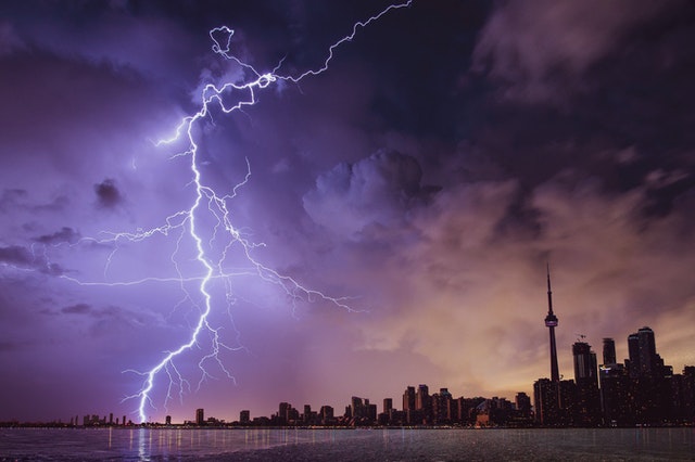 a picture of a lightning striking over the dark city in the background